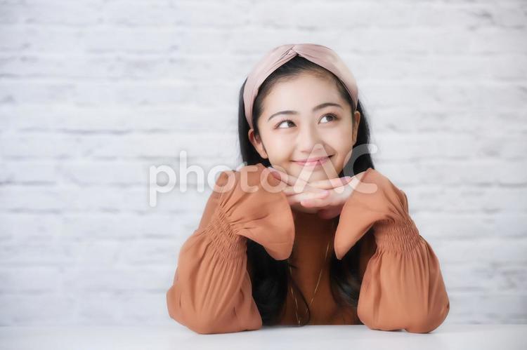 手の上に顎を乗せにやける女性 女性,若者,日本人の写真素材