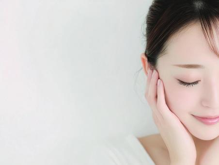 うつむいて笑顔の肌が綺麗な女性 うつむいて笑顔の肌が綺麗な女性の写真