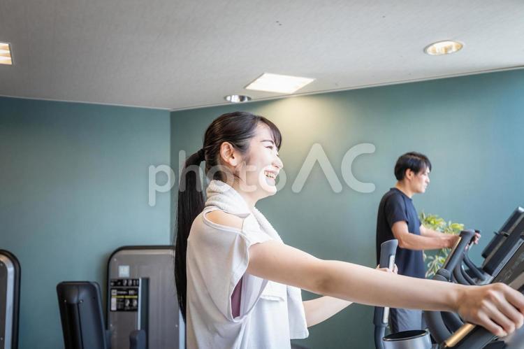 スポーツジムで運動する女性（男女・笑顔） スポーツジム,有酸素運動,運動の写真素材