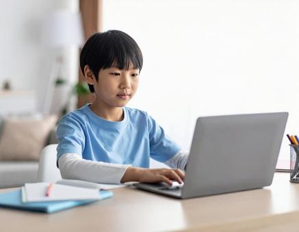 パソコンで勉強する小学生の男の子 パソコンで勉強する小学生の男の子の写真