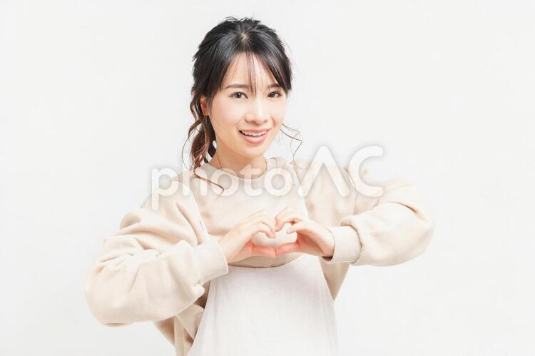 手でハートの形を作る若い女性 女性,ハート,気持ちの写真素材
