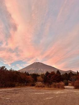 夕陽に染まる雲と富士山の写真