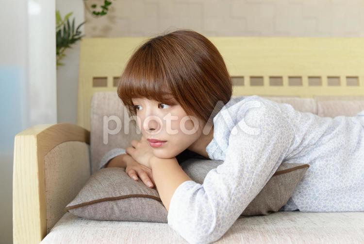 ソファーで横になる女性 女性,健康,寝そべるの写真素材
