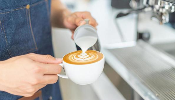 コーヒーラテアートを描くスタッフの手もと コーヒーラテアートを描くスタッフの手もとの写真
