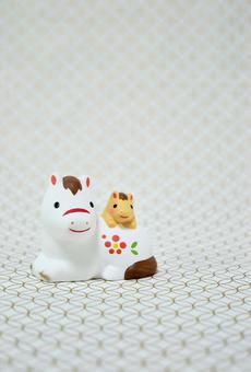 可愛い馬の置物と七宝柄の背景の年賀状素材の写真