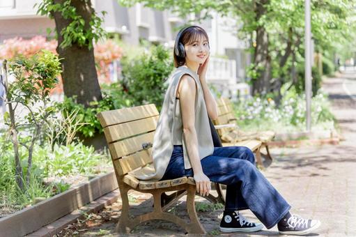 新緑の中ヘッドフォンで音楽を聴く若い女性 新緑の中ヘッドフォンで音楽を聴く若い女性 女性,人物,ヘッドフォンの写真素材