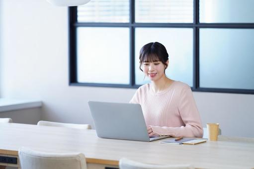 笑顔でパソコン作業をしている女性 笑顔でパソコン作業をしている女性の写真