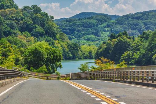 山並みと水辺の道、夏のドライブコース 夏,晴れ,入道雲の写真素材