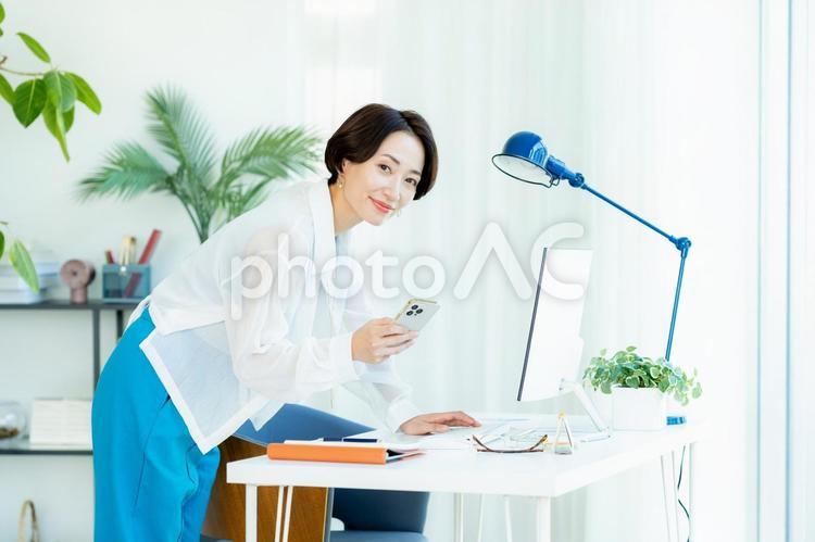 スマホを操作するビジネスウーマン スマホ,笑顔,ビジネスウーマンの写真素材