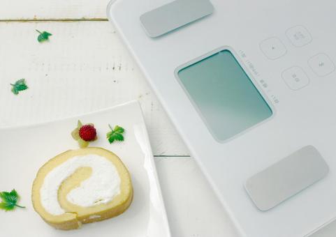 体重計とロールケーキの食事 体重計とロールケーキの食事 体重計,ロールケーキ,ケーキの写真素材