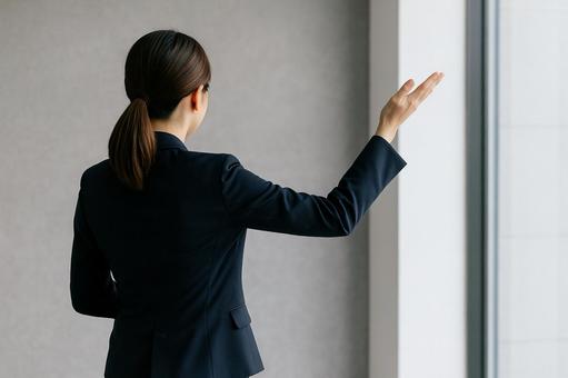 プレゼンする女性の後ろ姿の写真