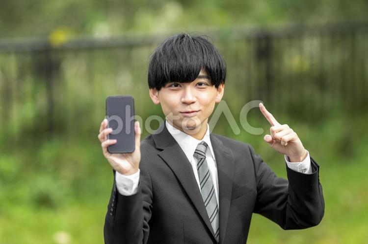 屋外でスマホを使うビジネスマン 就職,キャリア,若いの写真素材