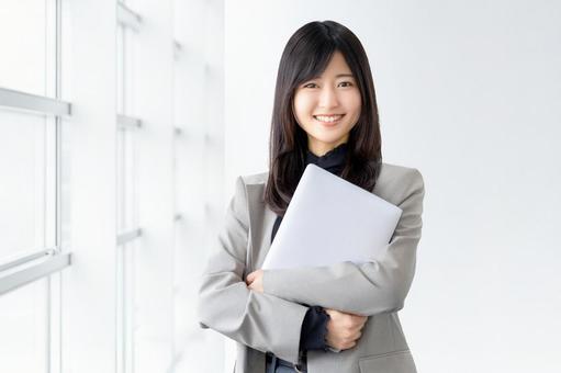 ノートパソコンを持つ笑顔の女性 ノートパソコンを持つ笑顔の女性 女性,パソコン,笑顔の写真素材