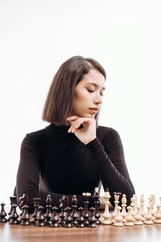 並べたチェスの駒と肘をついている女性(白背景) 並べたチェスの駒と肘をついている女性(白背景) チェス,女性,20代の写真素材