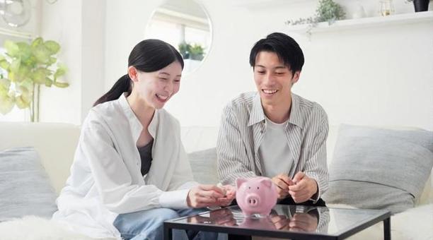 貯金箱にお金を入れるアジア人のカップル 貯金箱にお金を入れるアジア人のカップル 貯金,カップル,女性の写真素材