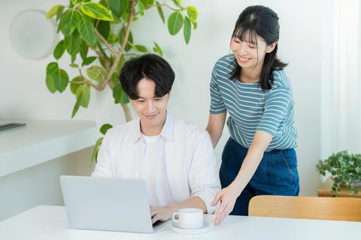 パソコンを見るカップル ノートパソコン,笑顔,カップルの写真素材