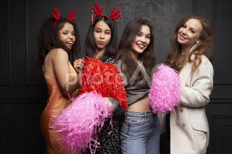 クリスマスパーティー　ポンポンを持って立つ女性たち クリスマスパーティー,クリスマス,パーティーの写真素材