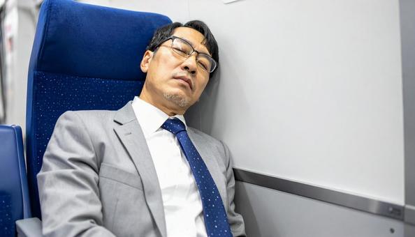 電車内で寝る中年男性 電車内で寝る中年男性の写真