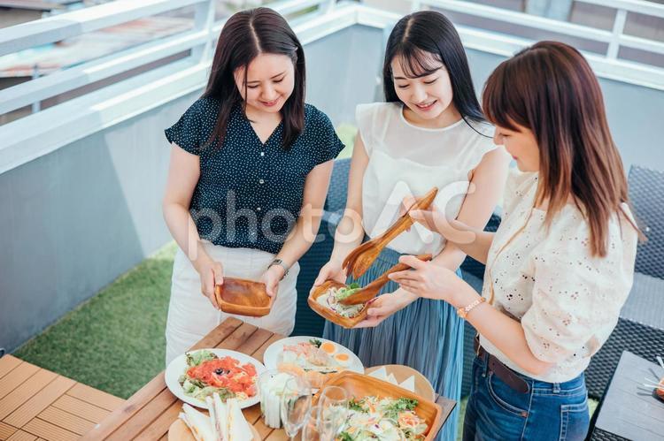 屋上でパーティーをする女性たち（盛る） 女子会,ホームパーティー,旅行の写真素材