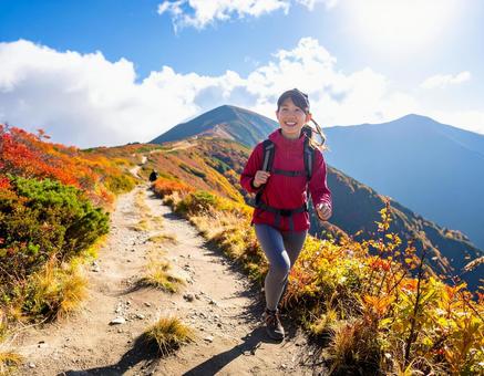 紅葉の中、登山を楽しむ山ガールの写真