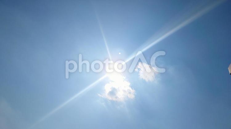 青空に描かれた十字の光条と雲に隠れた太陽 光条,日の光,晴れの写真素材