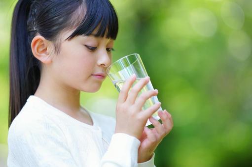 公園でグラスに入った水を飲む女の子 子ども,女の子,小学生の写真素材