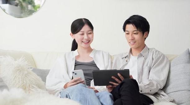 笑顔でタブレットを見るアジア人カップル 笑顔でタブレットを見るアジア人カップル タブレット,見る,男性の写真素材