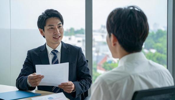 オフィスで商談する日本人ビジネスマン オフィスで商談する日本人ビジネスマンの写真