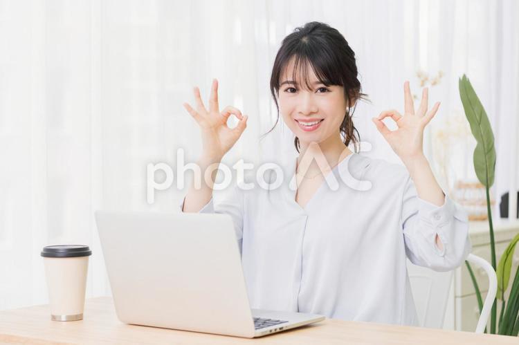 部屋でノートパソコンを使いながらOKのジェスチャーをする若い女性 女性,ノートパソコン,okの写真素材