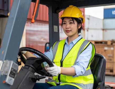 フォークリフトを運転する女性作業員の写真