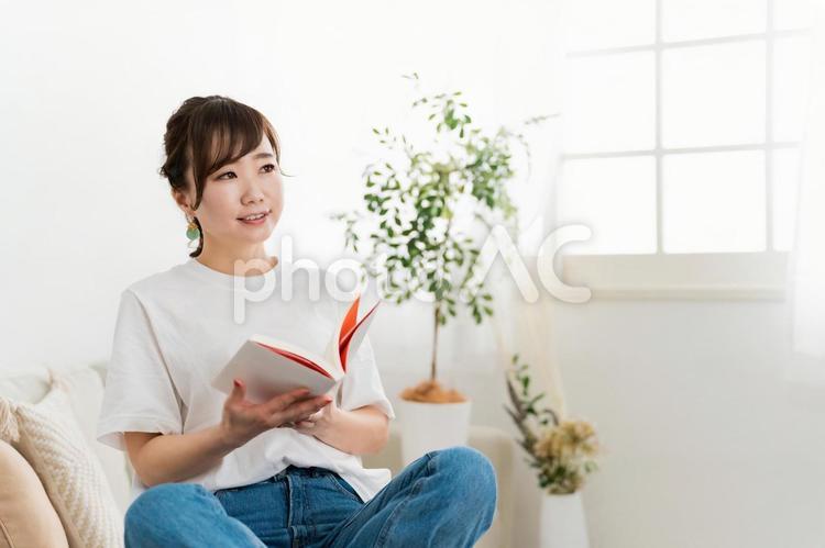 家のソファで本を読む日本人女性（読書） 勉強,読書,女性の写真素材