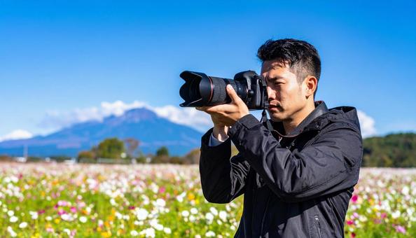 レンズを向ける日本人男性カメラマン レンズを向ける日本人男性カメラマンの写真