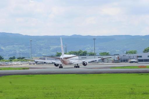 青空に吸い込まれる機影の写真