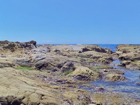 夏の青空と波が輝く岩場の海岸風景 磯,岩場,青空の写真素材