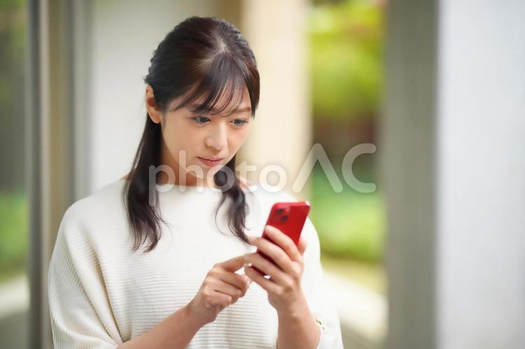 スマートフォンを見ている女性 女性,主婦,スマートフォンの写真素材