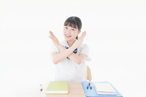 バツを示す制服姿の女子学生 バツを示す制服姿の女子学生 サイン,両手,不合格の写真素材