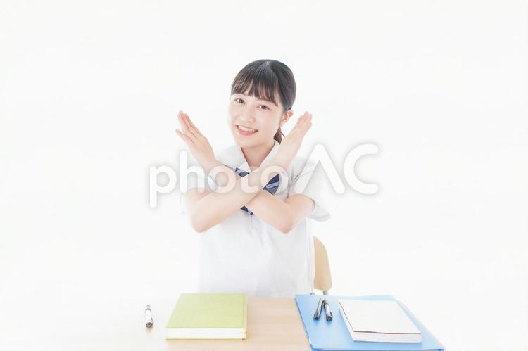 バツを示す制服姿の女子学生 サイン,両手,不合格の写真素材