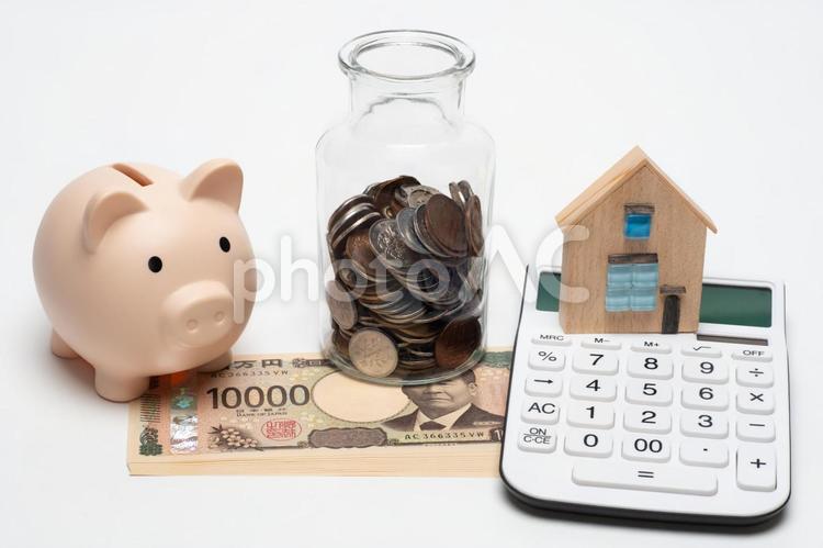 豚の貯金箱と電卓と一万円札と小銭 住宅ローン,マイホーム,お金の写真素材