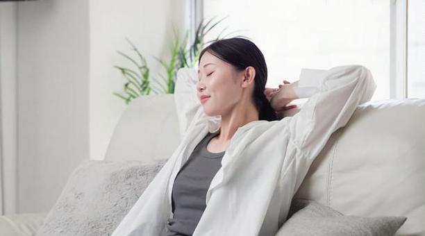 ソファで伸びをするアジア人女性 ソファで伸びをするアジア人女性 女性,伸び,ストレッチの写真素材