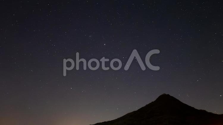 とんがり峰に広がる銀河の夜 とんがった山,星空,夜空の写真素材