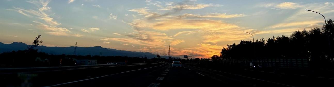 夕日をバックに走る車 夕日をバックに走る車の写真