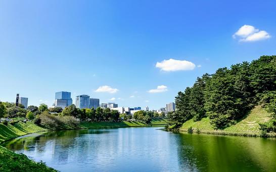 木々の緑を映す美しい皇居のお濠周辺の光景 木々の緑を映す美しい皇居のお濠周辺の光景 都市風景,桜田濠,水面の写真素材