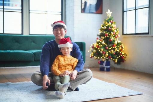 絨毯に座るサンタ帽の親子 絨毯に座るサンタ帽の親子 親子,男の子,小学生の写真素材