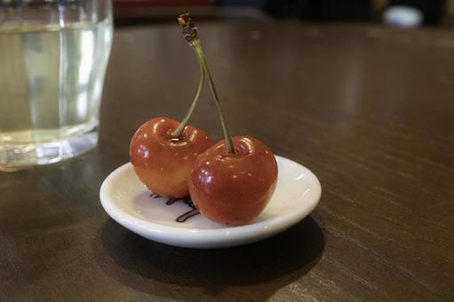 白い小さな皿に乗せたさくらんぼ 白い小さな皿に乗せたさくらんぼの写真