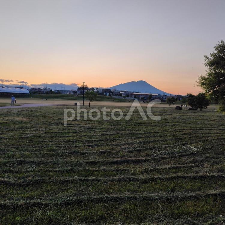 刈られた芝生と夕日に染まる空と山 夕日,雲,山の写真素材
