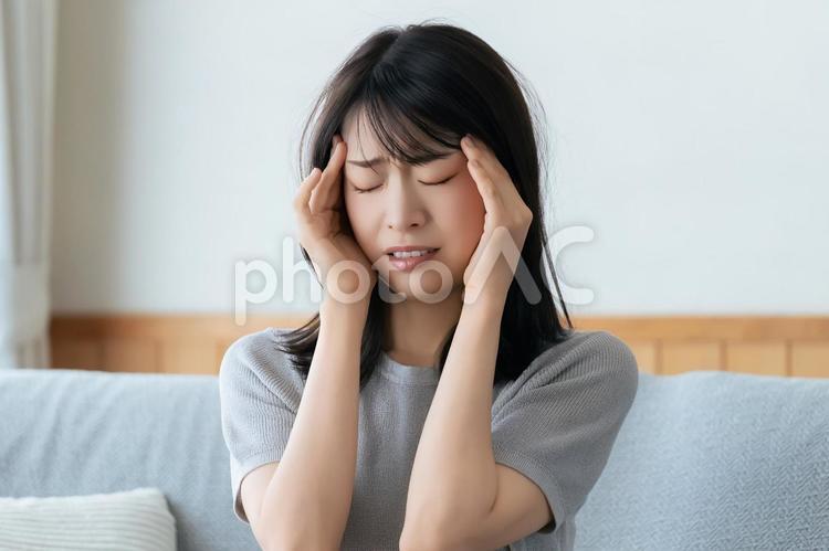 頭を押さえて悩む女性 女性,頭痛,つらいの写真素材