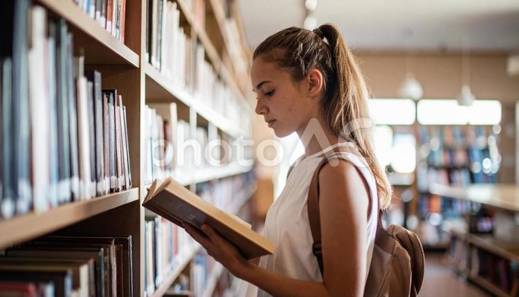 図書館で立ち読みをしている西洋人女性 本,女性,立ち読みの写真素材