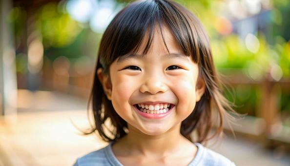 白い歯を見せて笑う女の子の写真