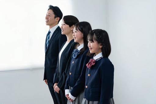 スーツを着た男女と制服を着た女の子二人 スーツを着た男女と制服を着た女の子二人 入学式,父母,母親の写真素材