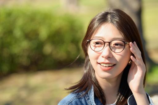 公園で微笑むメガネの女性 公園で微笑むメガネの女性 メガネ,眼鏡,公園の写真素材